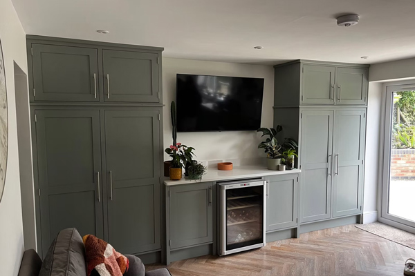 modern kitchen with gray cabinets television and wine fridge featuring three indoor plants
